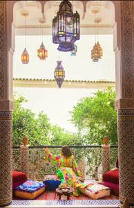 a young girl sitting on a balcony looking out a window at Riad Lalla Fatima in Fez