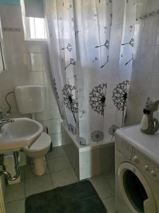 a bathroom with a toilet sink and a shower curtain at House Katarina in Ankaran