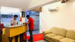 two men standing at a bar in a room at Half Moon Palace Chennai in Chennai