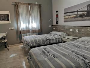 a hotel room with two beds and a desk at Villa "Luna de Segovia" in Leganés