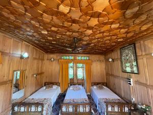 シュリーナガルにあるThe Shelter Group of Houseboats & Tour organiserのベッド2台とシャンデリアが備わる客室です。
