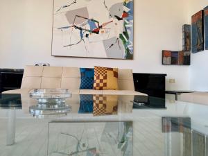 a living room with a couch and a glass table at Attico d'arte sulla Valle dei Templi in Agrigento