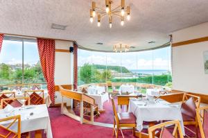 un restaurante con mesas y sillas y una gran ventana en The Esplanade Hotel en Scarborough