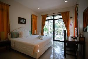 ダムヌーンサドゥワックにあるBaan Klong Resortのベッドと机と窓のある寝室