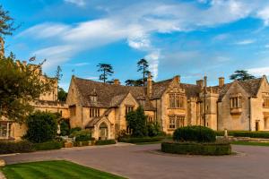 un domaine avec un grand bâtiment en pierre dans l'établissement Ellenborough Park, à Cheltenham