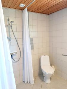 a bathroom with a toilet and a shower curtain at Skovly FerieCenter in Humble