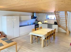a kitchen and dining room with a table and chairs at Skovly FerieCenter in Humble