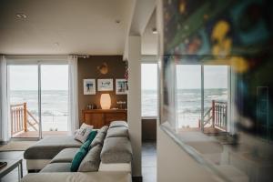 salon z kanapą i widokiem na ocean w obiekcie Villa Balaou - Vue mer exceptionnelle - w mieście Urville-Nacqueville