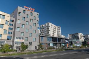 un edificio con un cartel en la parte superior junto a una calle en Appart-Hôtel Mer & Golf City Bordeaux Lac, en Burdeos