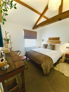 a bedroom with a large bed and a desk at The Cherry Tree in Kingston Blount