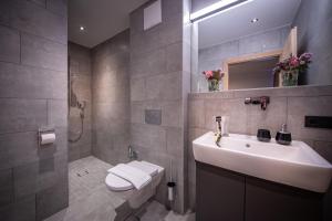 La salle de bains est pourvue d'un lavabo, de toilettes et d'une douche. dans l'établissement Sunny Ferienwohnungen Ski In - Ski Out, à Zell am See