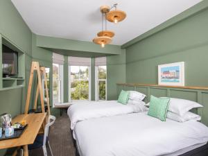 two beds in a room with green walls at The Broadmead in Falmouth