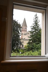 Blick auf ein Gebäude durch ein Fenster in der Unterkunft Hôtel Le Rempart in Tournus