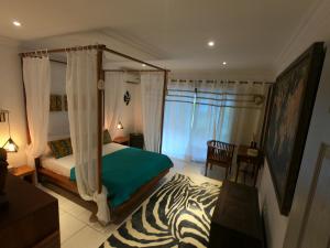 Un dormitorio con una cama con una alfombra de cebra. en sweet island en Rivière Noire