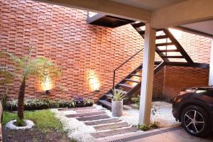 un mur en briques avec un escalier dans la cour dans l'établissement Luminosos y modernos departamentos en Rosario, à Rosario