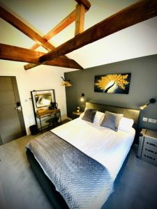 um quarto com uma grande cama branca e tectos em madeira em The Cherry Tree em Kingston Blount