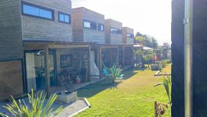 uma casa com um quintal com plantas em frente em Rosa Lodge Lofts em Praia do Rosa