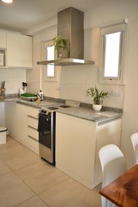 a kitchen with white cabinets and a counter top at Luminosos y modernos departamentos en Rosario in Rosario