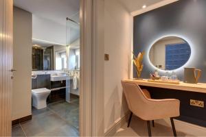 een badkamer met een wastafel, een toilet en een spiegel bij The Railway Hotel by Barefoot Retreats in Burnham Market