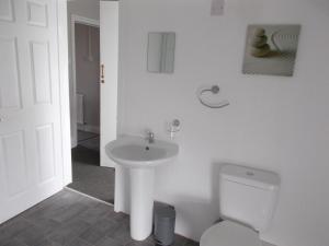 a white bathroom with a sink and a toilet at Kelso House holiday flats in Blackpool