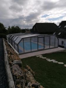 ein Glashaus mit einem Pool im Hof in der Unterkunft Gîte La feuille d'Acanthe in Bucilly
