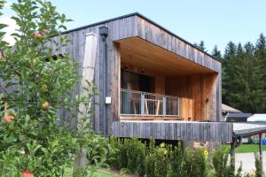 a wooden house with a balcony in a garden at Chalet M&M in Innsbruck