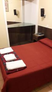 a hotel room with a red bed with towels on it at HOTEL KAPAC in Mendoza