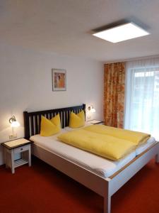 a bedroom with a large bed with yellow sheets and a window at Piz Buin in Kappl