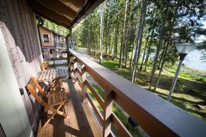 a porch of a cabin with a bench and a lamp at LVM tūrisma un atpūtas centrs "Spāre" in Spāre