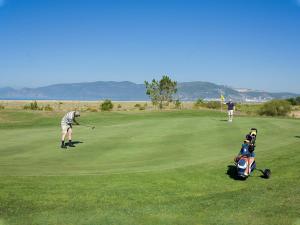 a man playing golf with a child in a stroller at Comporta beach house in Carvalhal
