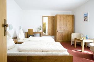 a bedroom with two beds and a table and chairs at Hotel Flora in Dormagen