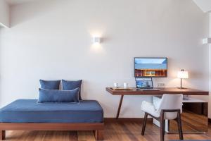 a bedroom with a bed and a desk with a laptop at Horizon Blu Boutique Hotel in Kalamata