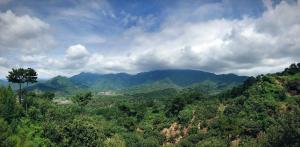 vistas a un valle de montaña con árboles y nubes en Home of the Great Wall en Huairou