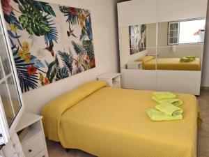 um quarto com uma cama amarela e um espelho em Casa Olivina em Puerto del Carmen