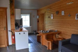 a room with a wooden wall with a table at Gîte du cheval blanc d'Houmont in Sainte-Ode