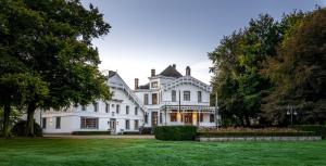 a large white house with a large yard at Landgoed Altenbroek in Voeren