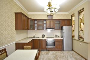 a kitchen with wooden cabinets and a refrigerator at Northern Avenue, 2 bedrooms Unique, Luxury apartment with Special Open balcony HH567 in Yerevan