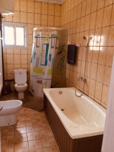 ヤウンデにあるVilla le Dakotaの浴槽、トイレ、洗面台を備えたバスルーム