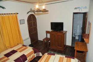 a bedroom with a bed and a tv and a room with at Casona Potosi in Potosí
