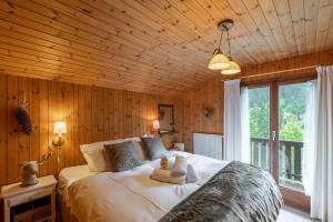 a bedroom with a large bed in a room with wooden walls at Chalet ChouChou in Morgins