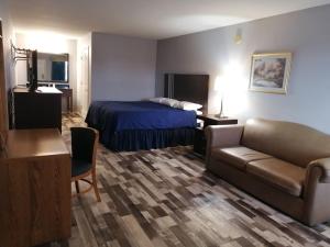 a hotel room with a bed and a couch at Riata Inn - Crystal City in Crystal City