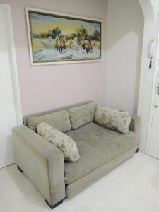un sofá en una sala de estar con una foto en la pared en Santana Temporada - Nossa Senhora de Copacabana Apartments, en Río de Janeiro