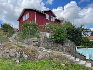 una casa roja sentada en la cima de una colina en Apartment Uddevalla Bohuslän Bubbelbad, en Uddevalla