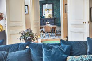 a living room with a blue couch and a table at Demeure de Manneville - SPA - 1Km des plages de Cabourg in Dives-sur-Mer