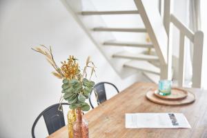 a wooden table with a vase with a plant on it at Demeure de Manneville - SPA - 1Km des plages de Cabourg in Dives-sur-Mer
