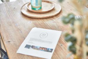 a table with a menu and a drink on it at Demeure de Manneville - SPA - 1Km des plages de Cabourg in Dives-sur-Mer