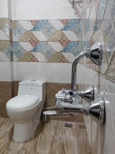 a bathroom with a toilet and a tile wall at SRI VIGNESH RESIDENCY in Chennai