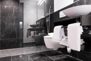 ein schwarz-weißes Bad mit WC und Waschbecken in der Unterkunft Blackhome Innsbruck City South I contactless check-in in Innsbruck
