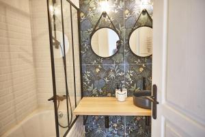a bathroom with a shower with two mirrors on the wall at Demeure de Manneville - SPA - 1Km des plages de Cabourg in Dives-sur-Mer