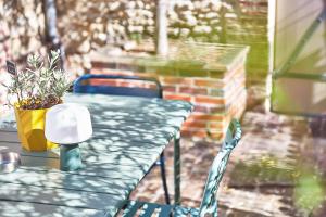 a green table and chairs on a patio at Demeure de Manneville - SPA - 1Km des plages de Cabourg in Dives-sur-Mer